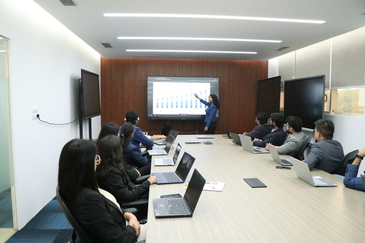 A team in the boardroom watching a presentation on a large interactive display
