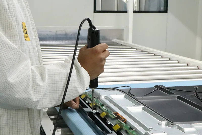 Technicians assembling display panels on the Noida production line